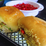 Dabeli is a spicy, tangy Indian street food from Gujarat, made with a flavorful potato filling, chutneys, crunchy peanuts, and pomegranate seeds, all stuffed in a buttery pav. It’s a delicious explosion of sweet, sour, and savory in every bite!