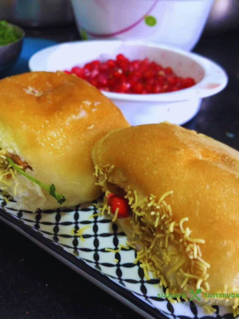 Dabeli is a spicy, tangy Indian street food from Gujarat, made with a flavorful potato filling, chutneys, crunchy peanuts, and pomegranate seeds, all stuffed in a buttery pav. It’s a delicious explosion of sweet, sour, and savory in every bite! 